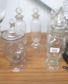 5 glass apothecary bottles.