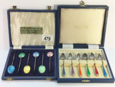 A cased set of 6 silver and enamel spoons together with a cased set of enamel spoons.