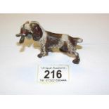 A cold painted bronze spaniel with a duck in its mouth.