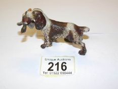 A cold painted bronze spaniel with a duck in its mouth.