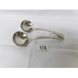 A pair of silver sauce ladles.