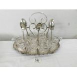 A silver plate tea stand with 6 glass teacups (missing one spoon).