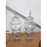 A pair of lidded glass apothecary jars.