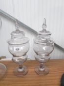 A pair of lidded glass apothecary jars.