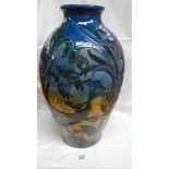 A huge vase decorated with a peacock and flowers.