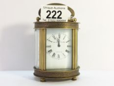 An oval chased brass carriage clock marked Elliot & Son, London, in working order.