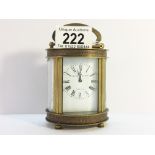 An oval chased brass carriage clock marked Elliot & Son, London, in working order.