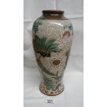 A large Doulton vase with large floral pattern in whites and greens on fawn ground.