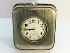 A silver fronted travel clock case with 8 day travel clock (clock not silver).