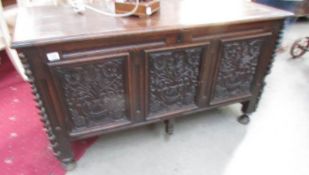 An 18th century oak coffer with carved panels to sides and front.