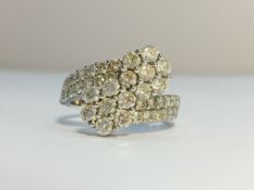 An 18ct gold and diamond ring fashioned as crossing flowers, size M.