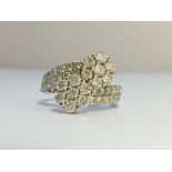 An 18ct gold and diamond ring fashioned as crossing flowers, size M.