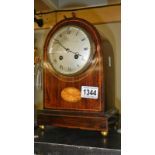 An inlaid mahogany dome top mantle clock with silvered dial