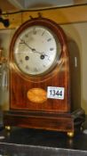 An inlaid mahogany dome top mantle clock with silvered dial