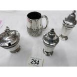 A silver three piece condiment set and a silver mug.