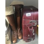 A pair of ladies knee high boots and a suitcase
