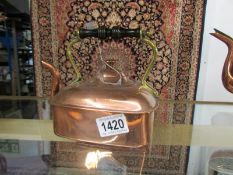 A small square copper kettle.