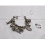 A circa 1960/70's heavy quality charm bracelet with 11 interesting charms in silver,