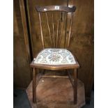 A small upholstered bedroom chair with sunburst dowel back