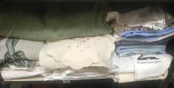 A shelf of linen, table cloths, tea towels & sheets etc.