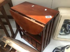 A dark wood stained drop leaf table magazine rack