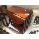 A dark wood stained drop leaf table magazine rack