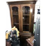 A corner cabinet with glazed display top half