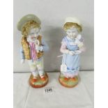 A pair of 19th century porcelain figures of children. 25 cm tall.