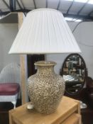A large pottery table lamp and shade