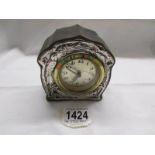 A small clock with silver front.