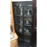 A dark oak leaded glass corner cupboard