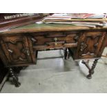 An oak writing desk with green leather inset top.