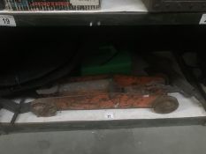 A shelf of car accessories including 2 scissor jacks, an old trolley jack,