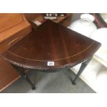 A darkwood stained corner table with string inlay