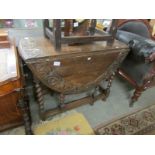 An oak barley twist gate leg table with carved edge.