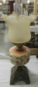 An oil lamp with hand painted glass font and later shade.