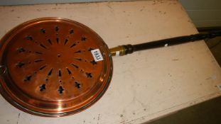 A Victorian copper warming pan.