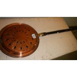 A Victorian copper warming pan.