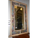 A wall mirror with stained glass surround.