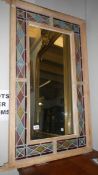 A wall mirror with stained glass surround.