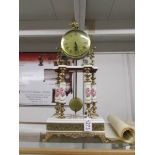 A Capo di monte clock with key and pendulum.