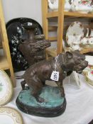 A bronze figure of a tethered dog (possibly pit bull terrier).
