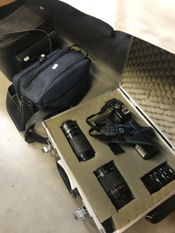 A Praktica bx20 camera plus accessories in silver camera box with other cameras/accessories