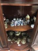2 shelves of pottery and brassware including Wedgwood container, brass vases etc.