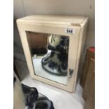 A vintage bathroom cabinet with bevelled mirrored door