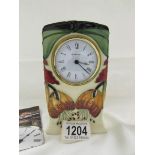 A Moorcroft mantel clock, 15cm tall.