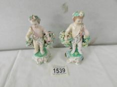 A pair of 19th century cherub figurines with flowers, 12 cm tall.