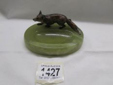 A cold cast bronze fox surmounted on an onyx ashtray.