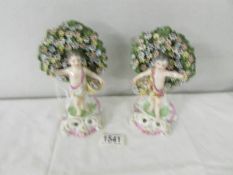 A pair of 19th century porcelain floral encrusted figures,. 18 cm tall.