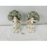 A pair of 19th century porcelain floral encrusted figures,. 18 cm tall.